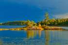 Canada-Ontario-Kenora District Forest autumn colors reflect on Middle Lake at sunset Art Print
